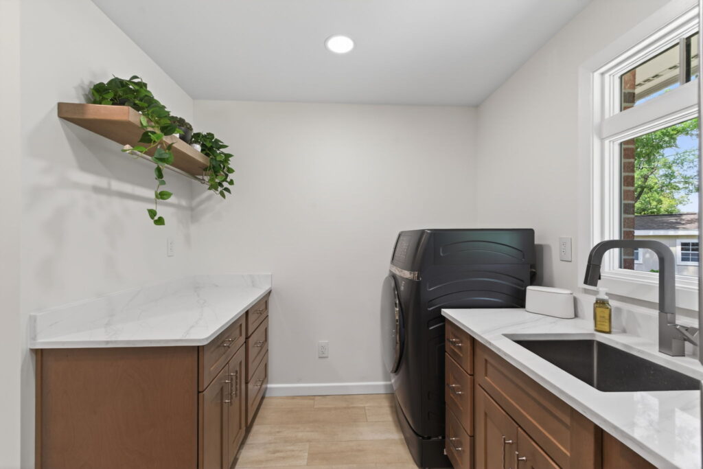 Custom bathroom addition featuring laundry area, utility sink, and storage for convenient cleanup after outdoor events