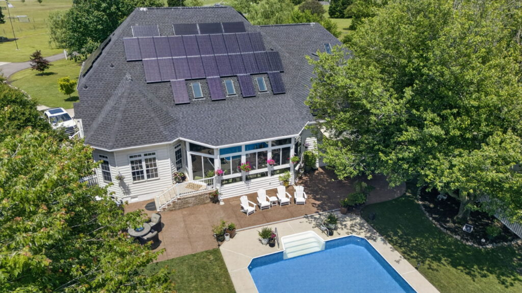 Aerial view of sunroom, roof, and patio
