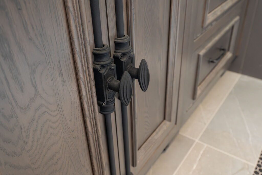 Cremone bolt style hardware adds wrought-iron character to the cabinetry.