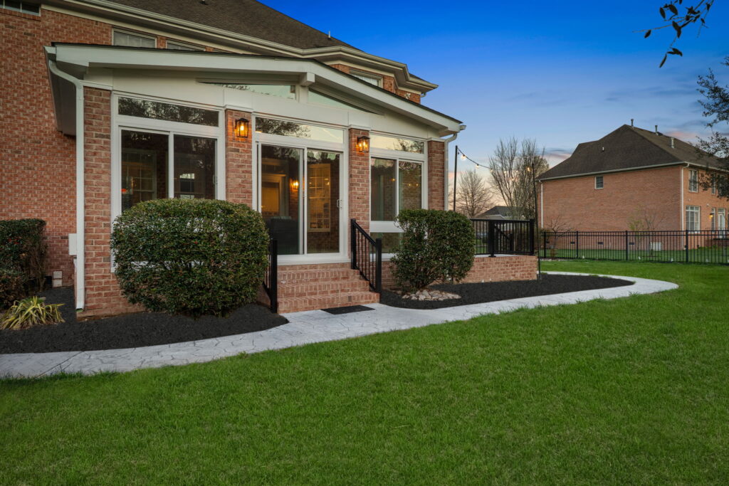 Brick steps and railing leading to sunroom and deck area