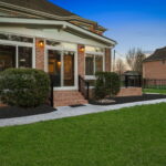 Brick steps and railing leading to sunroom and deck area