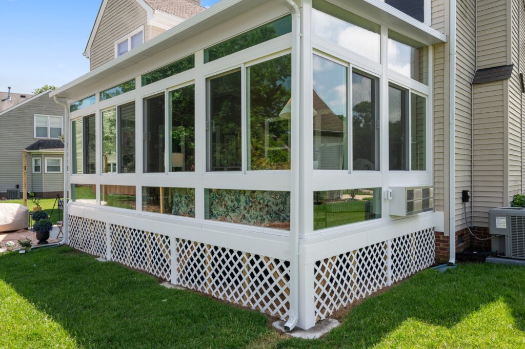 Exterior view of a newly built Betterliving 4-season studio sunroom in Virginia Beach, VA – showcases lattice skirting and sleek vinyl frame construction.