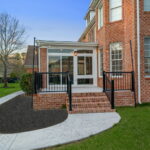 Composite deck and patio connected to custom sunroom addition