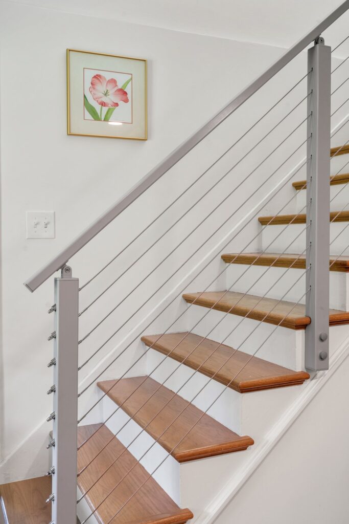The original banister was removed and replaced with a modern aluminum railing system, mirroring the updated style and clean lines of the downstairs renovation.