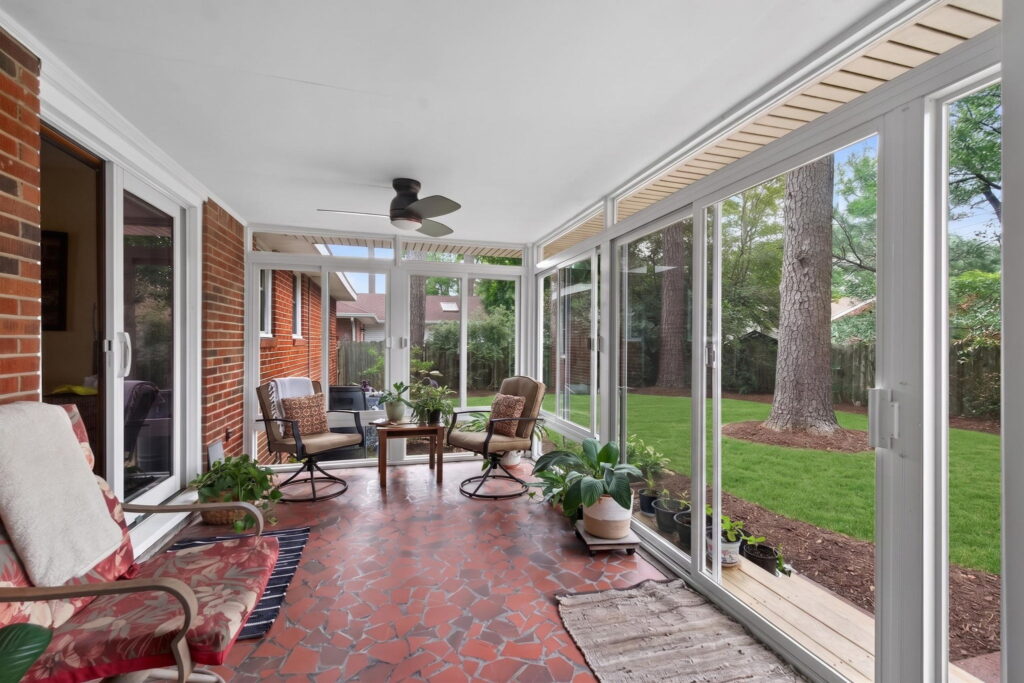 Bright and airy 3 season sunroom overlooking a backyard garden and birdwatching area in Norfolk, Virginia.