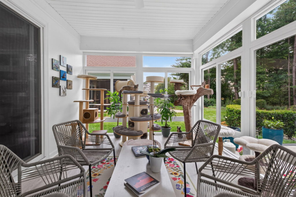 Spacious 3-season sunroom with panoramic backyard views and abundant natural light.