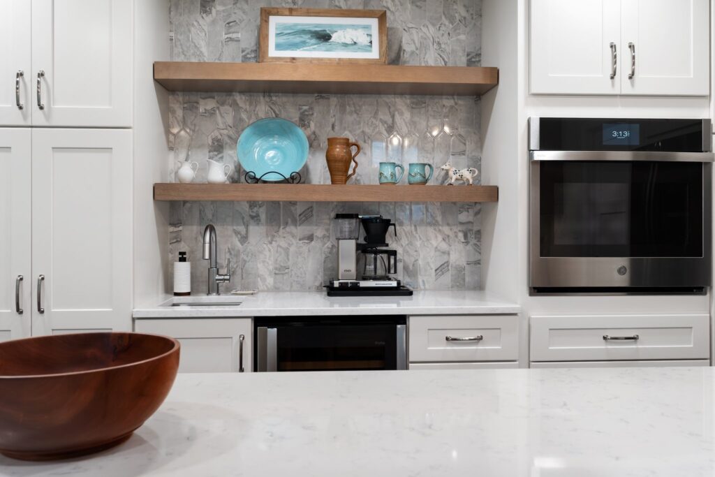 Built-in coffee/wine bar with Daltile Divinium Zion Picket tile and custom white oak shelves. Includes a beverage sink for convenience.