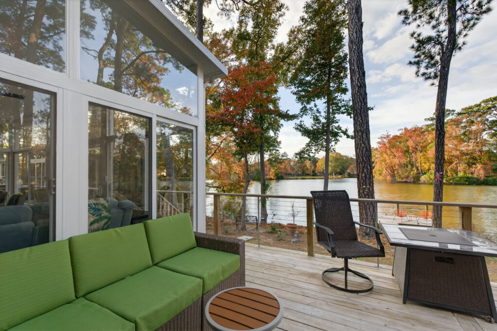 Exterior view of the Betterliving 3-season sunroom seamlessly connected to the outdoor deck, creating the perfect lakeside entertaining space.