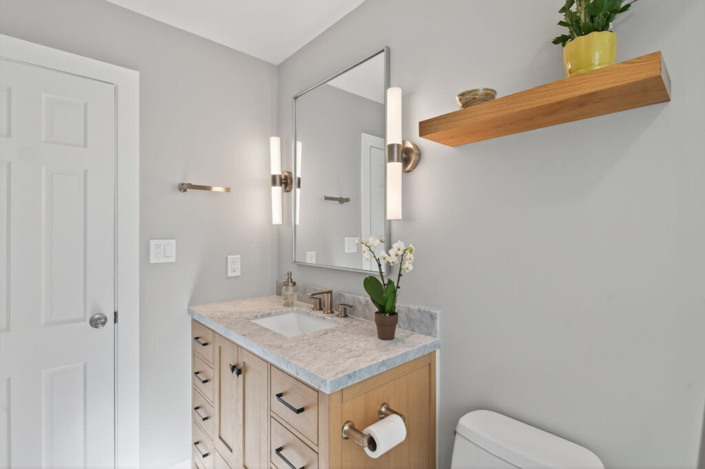 A floating white oak shelf adds soft warmth and a custom touch, providing extra display or storage without overwhelming the space.