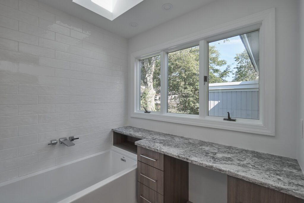 We also included additional countertop space dedicated to makeup and personal care items. This expanded area offers ample room for daily routines, making it easy to stay organized. Beneath the counters, deep drawers and cabinets provide plenty of storage for bathroom essentials, eliminating clutter and keeping everything within reach. These storage solutions are perfect for maintaining a clean, streamlined look, giving the bathroom a sense of order and luxury that complements its new open, modern layout.