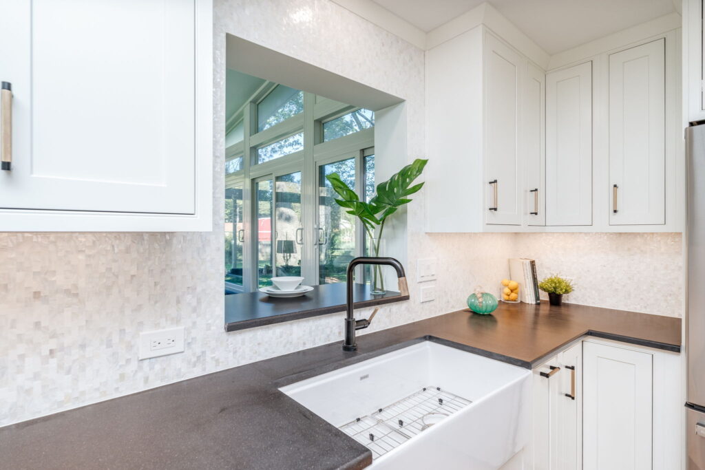 Elkay 33-inch farmhouse sink with Brizo Litze matte black and luxe gold faucet installed in a custom Virginia Beach kitchen remodel by McDrake Remodeling.