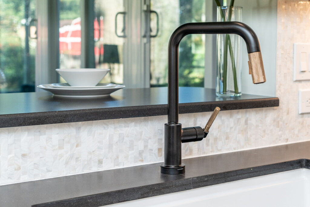 Elkay 33-inch farmhouse sink paired with Brizo Litze matte black and luxe gold faucet in a newly remodeled Kings Grant Virginia Beach kitchen.